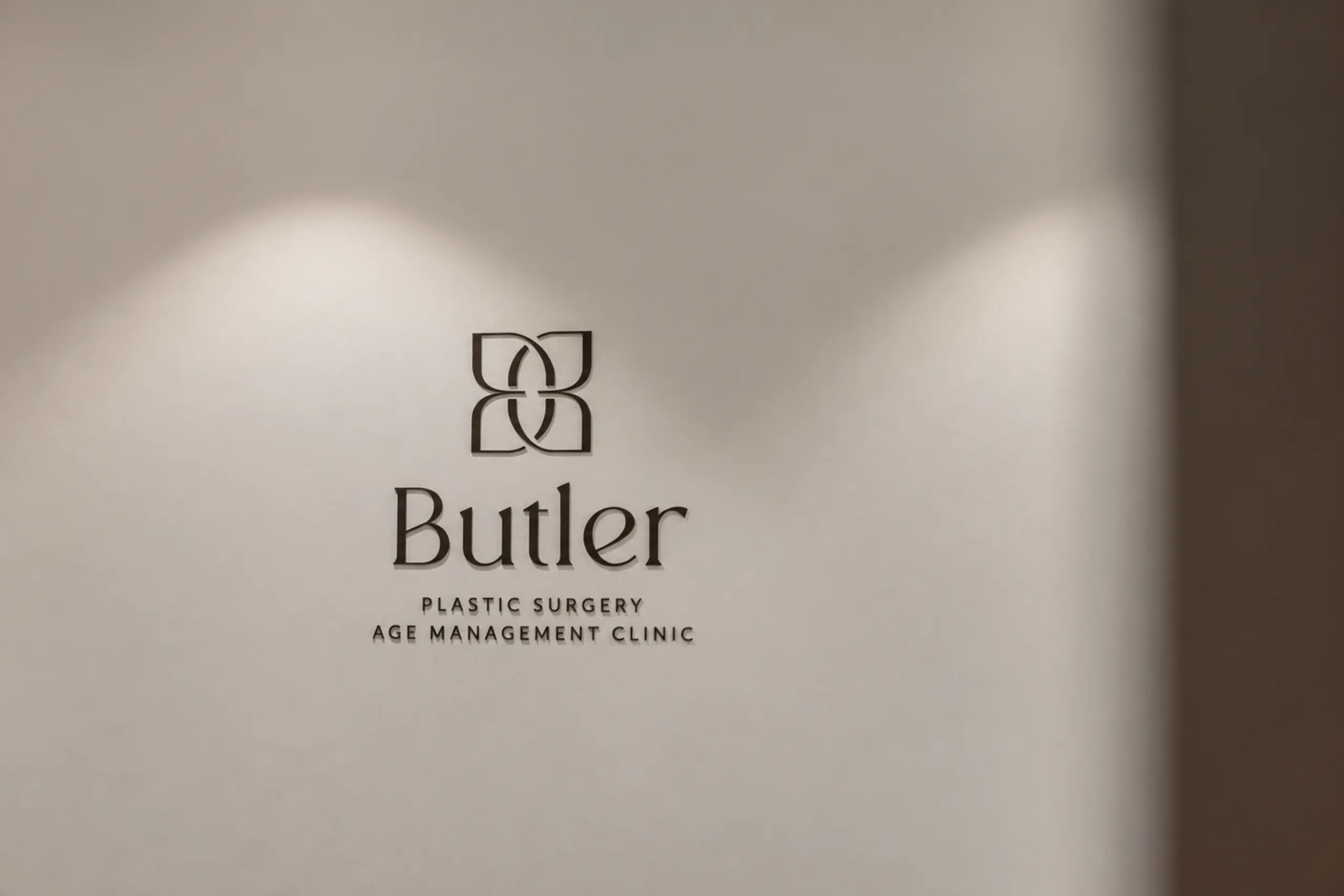 Butler Plastic Surgery Clinic logo on the treatment room wall
